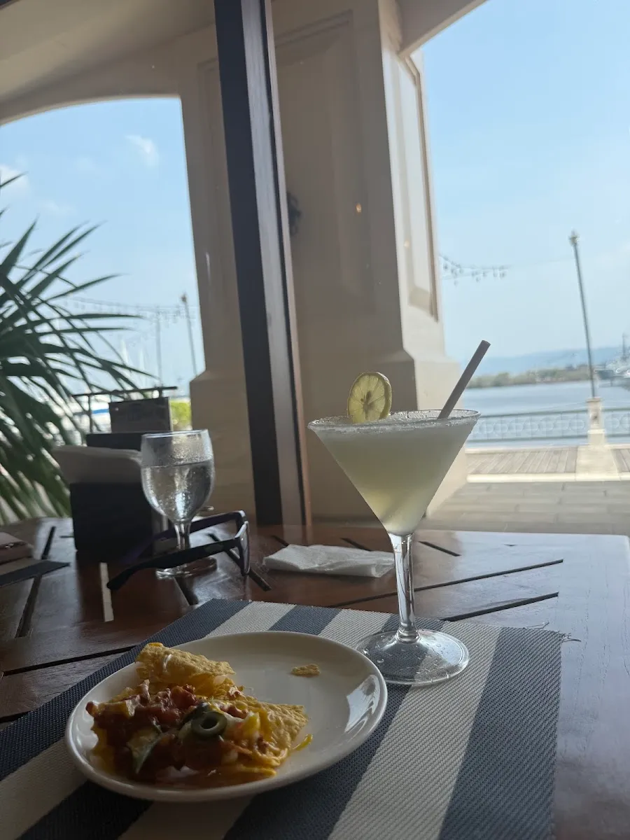 Cocktail and plate at a window table
